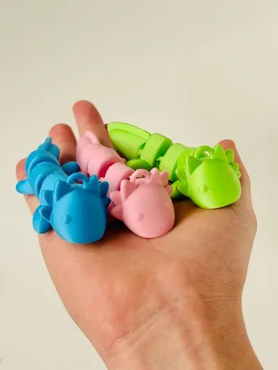 a hand holding several small toy animals in it's palm