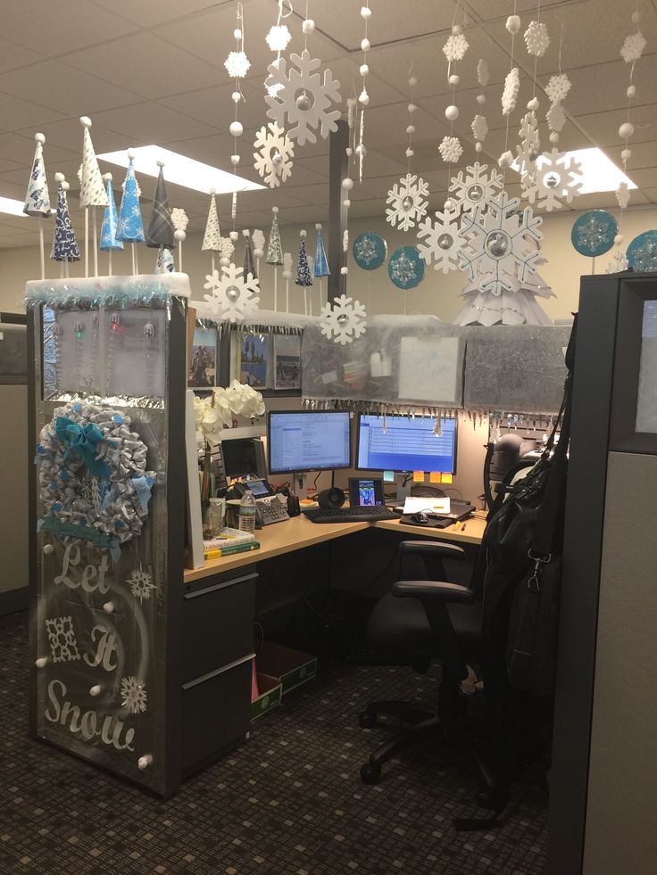 an office cubicle decorated for christmas with snowflakes hanging from the ceiling