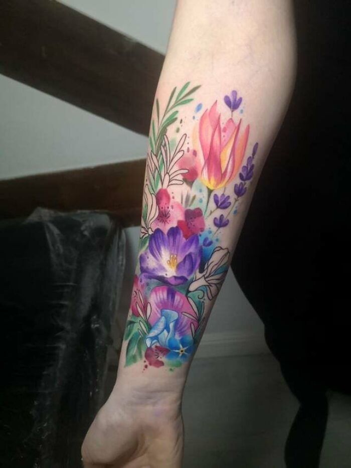 a woman's arm with flowers painted on it