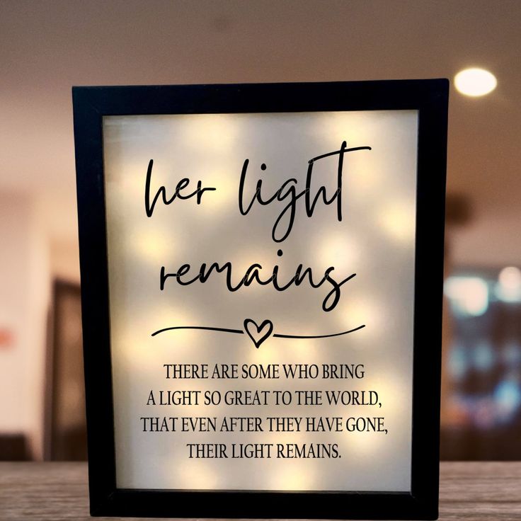 there are some lights in the frame on the table and it says, her light remains