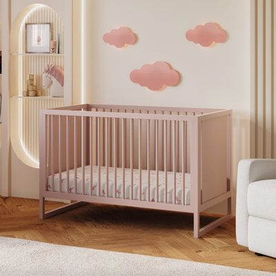 a baby's room with pink clouds on the wall