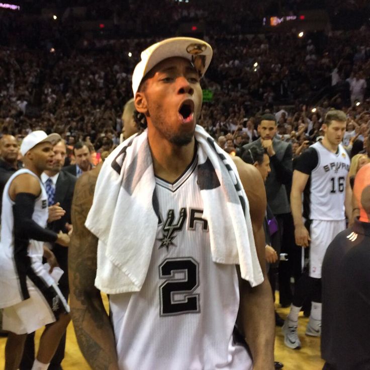 a basketball player with his mouth open in the middle of a court surrounded by other players