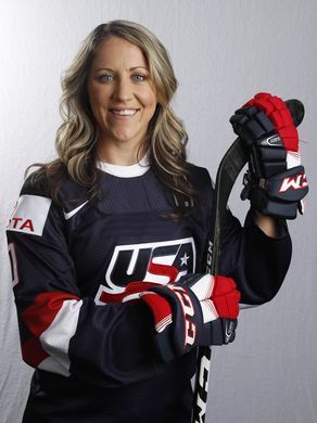 a woman is posing with her hockey gloves