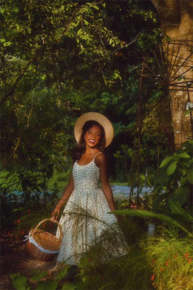 a woman in a white dress and straw hat holding a basket