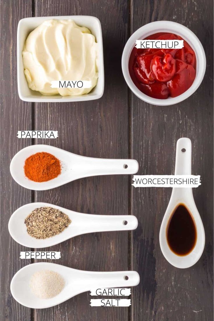 the ingredients to make homemade mayonnaise in small white bowls on a wooden table