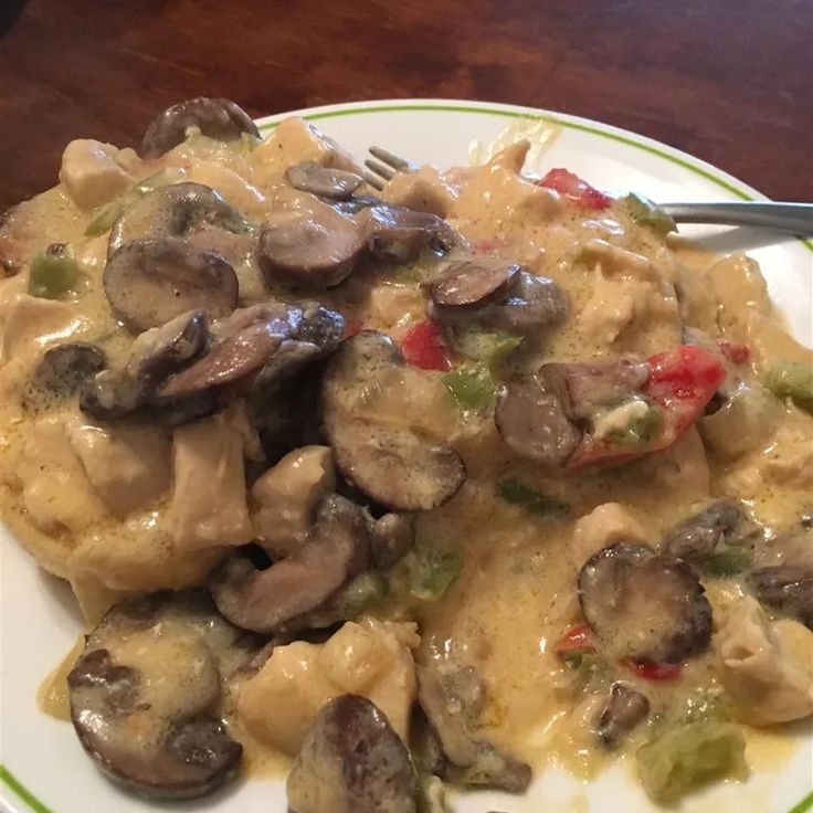 a white plate topped with pasta covered in mushrooms