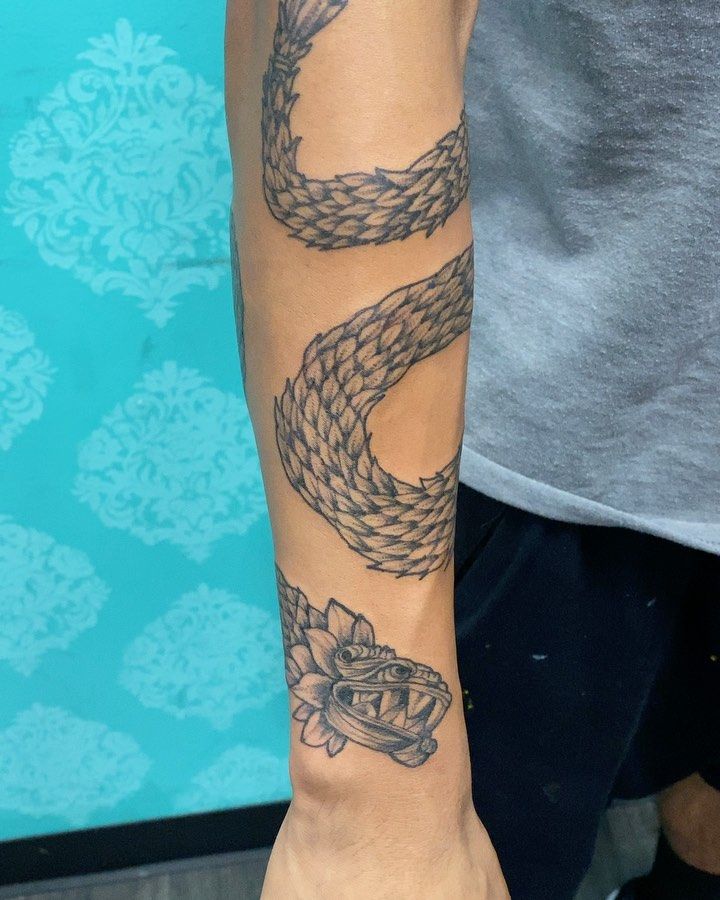 a person with a snake tattoo on their arm