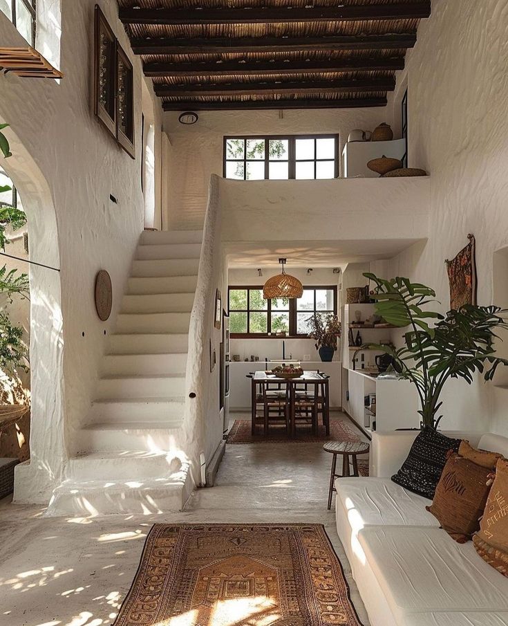 a living room filled with furniture next to a staircase leading up to a second story