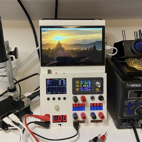 an array of electronic devices and equipment on a white table with wires, plugged in