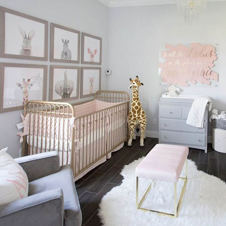 a baby's room with a giraffe in the corner and pictures on the wall