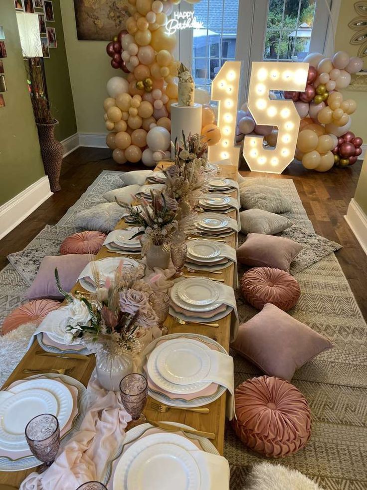 a table is set with plates and napkins for a party or celebration in front of balloons