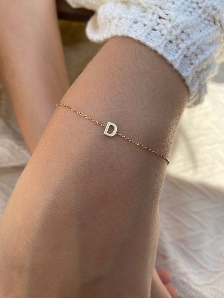 "Add a personal touch with this dainty initial bracelet.  DETAILS - Crafted with 14k solid gold - Chain style may vary slightly - Handmade in our New York City studio DIMENSIONS - Dimensions will vary depending on the letter - Bracelets are available in 6\", 7\", and 8\" with 1/2\" adjustable loops VARIATIONS If you require any variation of this style (smaller or larger nameplate, longer chain, longer name, etc.) feel free to message us. We will do our best to accommodate you. Additional costs may apply depending on the variation. POLICY This item is made to order. Made to order items are final sale and sometimes require additional production time. However, our goal is to give you something you love. If you have any questions, concerns, or are unsatisfied in any way with your order, feel f D Initial Bracelet, Dainty Initial Bracelet, Initials Bracelet, Custom Bracelet, Pretty Gold Necklaces, Initial Bracelet Gold, Letter Bracelet, Solid Gold Chains, Initial Jewelry