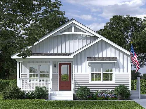 a small white house with a flag on the front porch and windows in the back