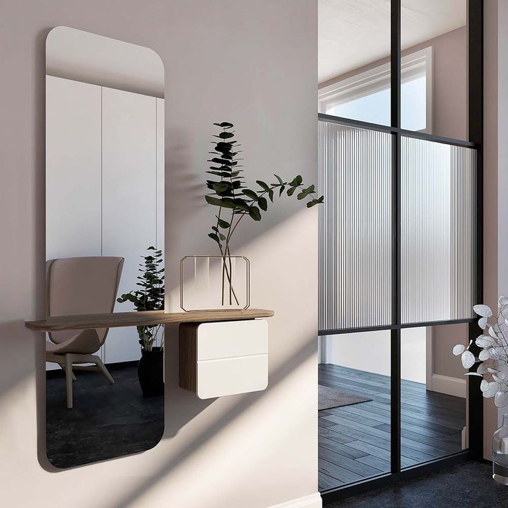 a room with a desk, mirror and plant in it