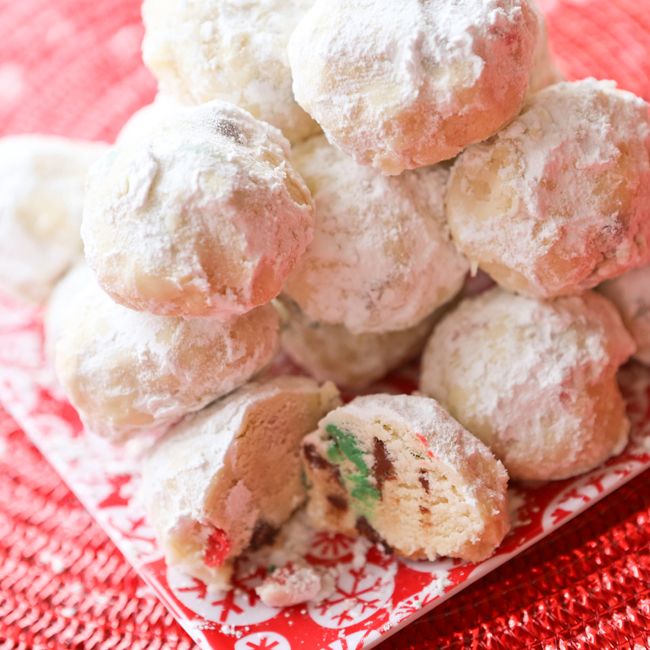 a pile of powdered sugar cookies sitting on top of a red and white plate