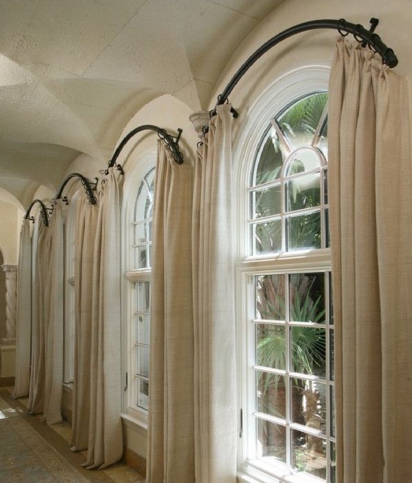 a row of windows with curtains hanging from them