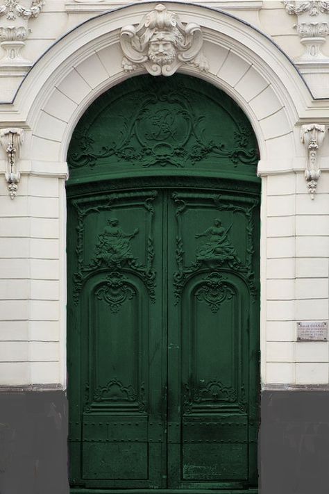 a large green door on the side of a building