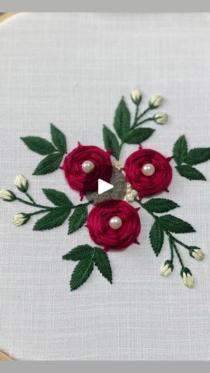 a close up of a piece of cloth with flowers and leaves on it, stitched together