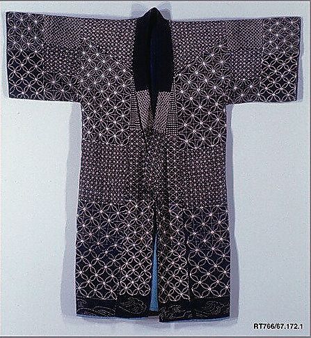 an old black and white kimono is hanging on the wall