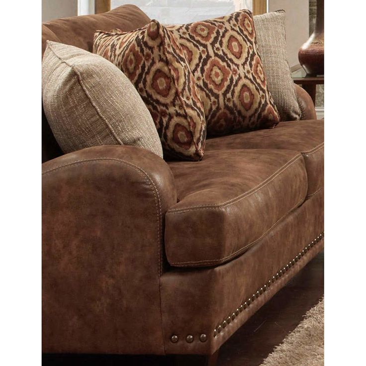 a brown couch with pillows on top of it