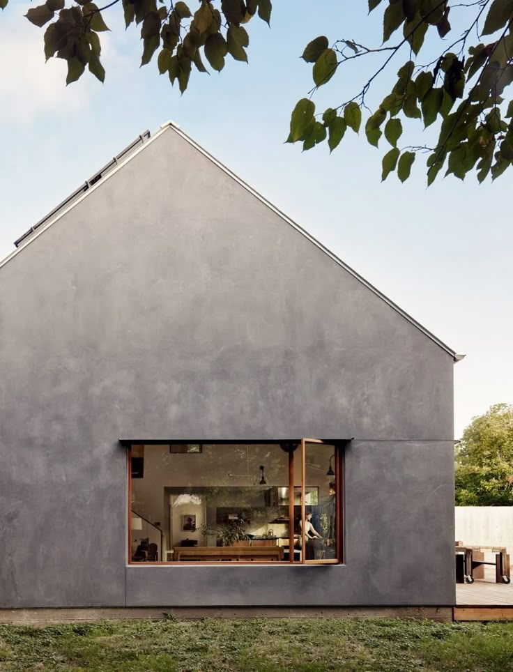 the house is made out of concrete and has an open window to let in light