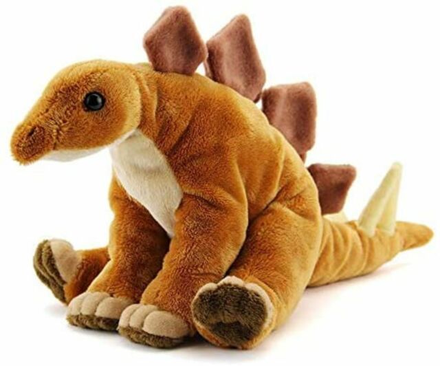 a small stuffed dinosaur sitting on the ground