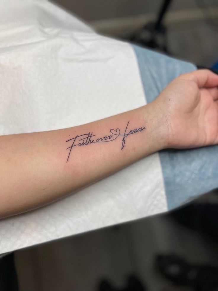 a woman's arm with a tattoo that reads faith and hope on the wrist