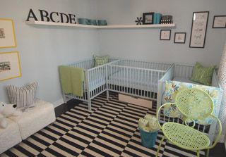 a baby's room with black and white checkered flooring, green cribs, and pictures on the wall