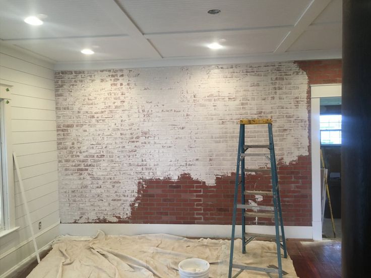 a brick wall is being painted with white paint