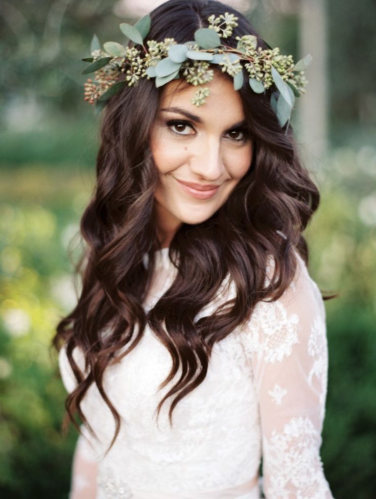 a woman with long hair wearing a white dress and a flower crown on her head