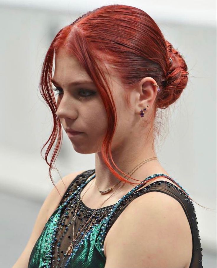 a woman with red hair wearing a green dress