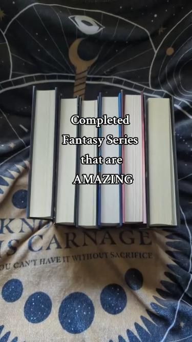 a stack of books sitting on top of a bed with the words completed fantasy series that are amazing