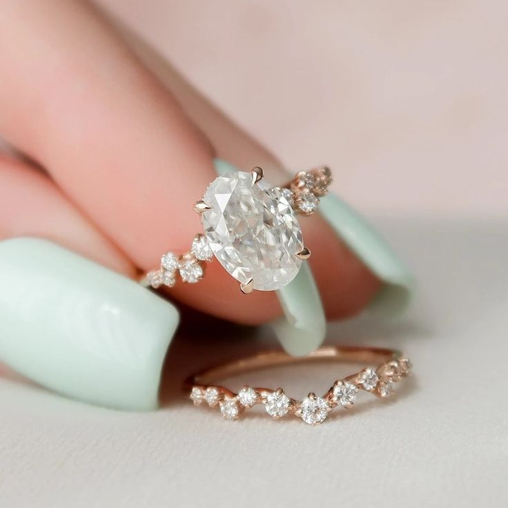 a woman's hand holding an engagement ring with a diamond on it and two diamonds in the middle