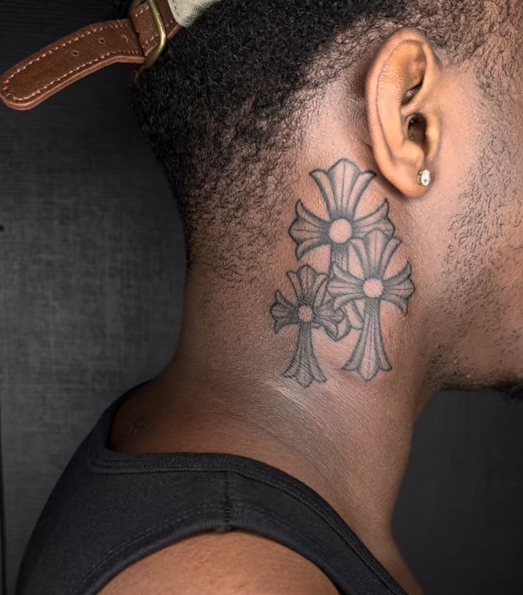 a man with a cross tattoo on his neck and behind his ear is a brown leather belt