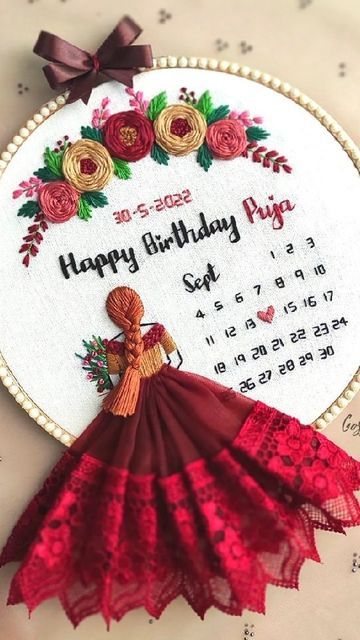 an embroidered birthday card with a red dress on it