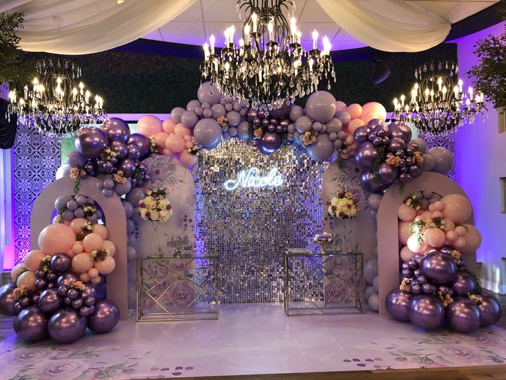 a decorated stage with balloons and chandeliers