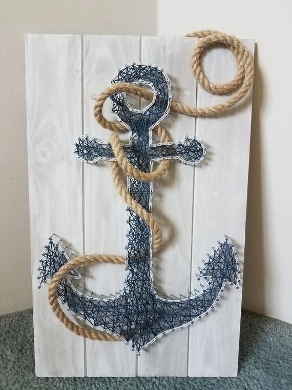 an anchor made out of rope on top of a white board with blue and gray paint