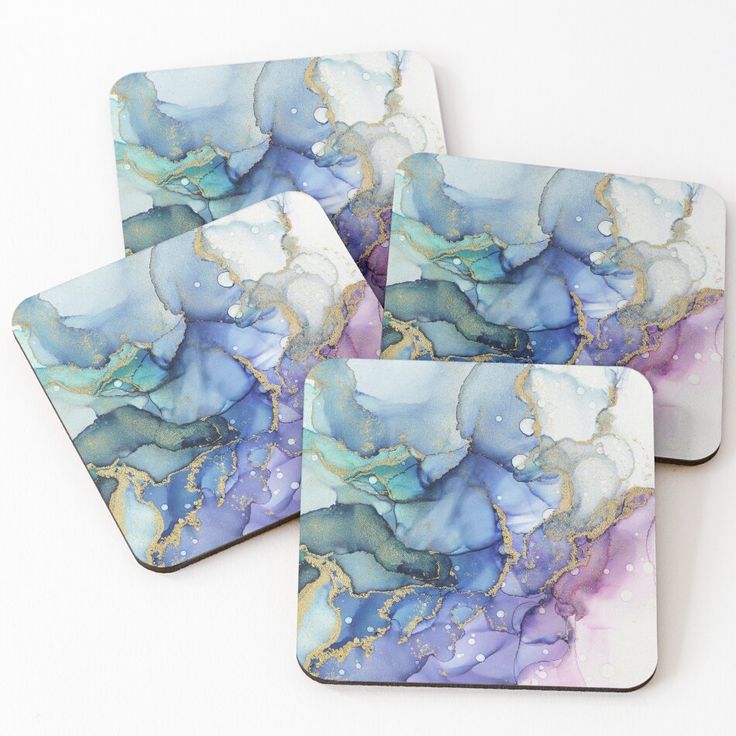 four coasters with blue, purple and gold designs on the top one has watercolor paint