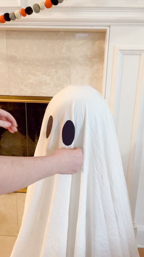 a person is making a fake ghost out of toilet paper on the fireplace mantel