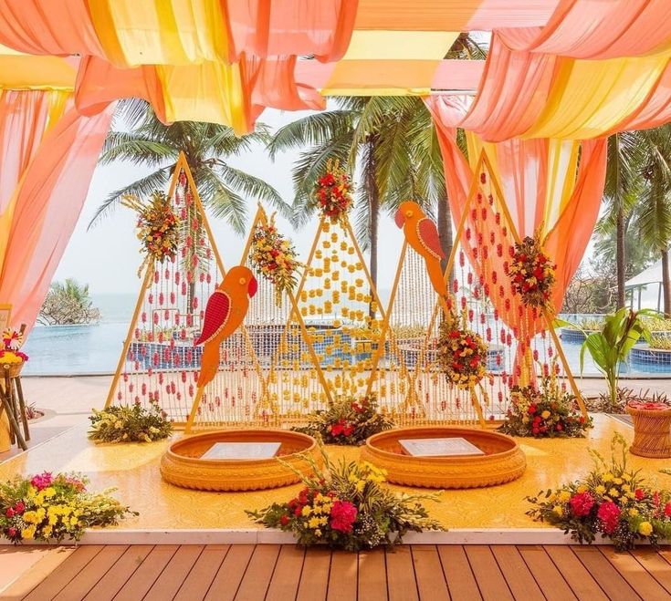 an outdoor ceremony setup with flowers and decorations on the floor, decorated in bright colors