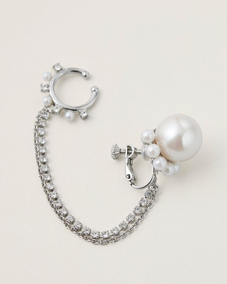 This modern and playful 4-way chained earring is inspired by this season's gothic rock theme. Cast from silver plated brass with delicate faux pearls and luminous crystals. The ear cuff is linked to the bottom pearl earring with chains, it can be detached and worn as a nose ring for elevating a glam punk look. You can also wear the pearl earring as a single piece with dangling chains.