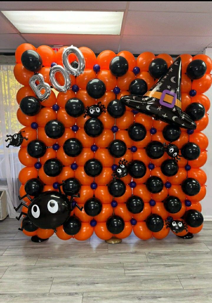 an orange and black balloon wall with balloons attached to it