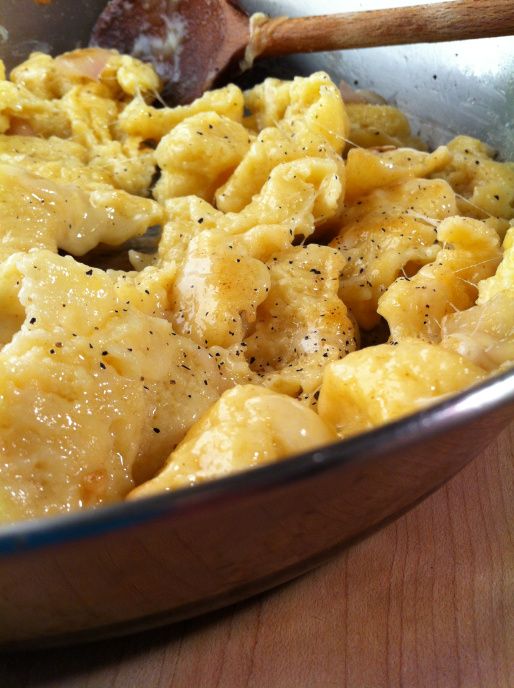 a bowl filled with macaroni and cheese on top of a wooden table