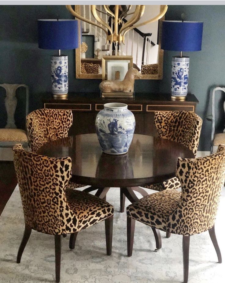 a dining room table with leopard print chairs