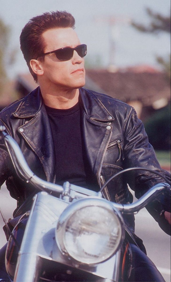 a man in black jacket and sunglasses on motorcycle