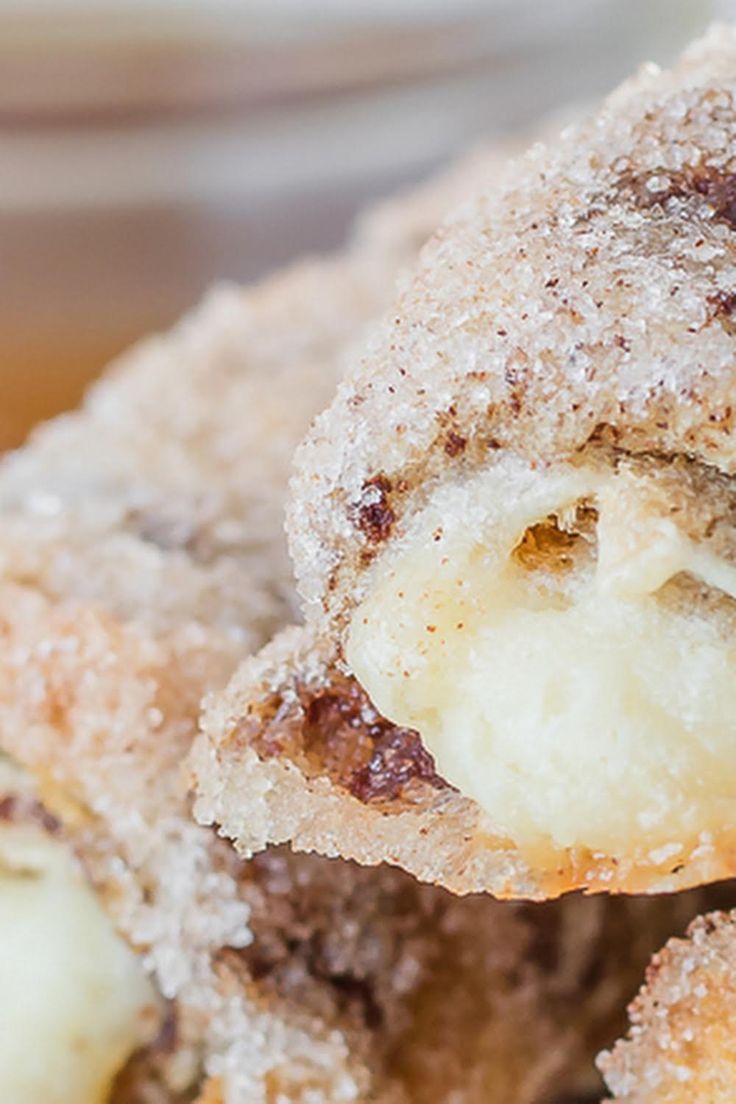 some sugar covered doughnuts are stacked on top of each other with one bite taken out