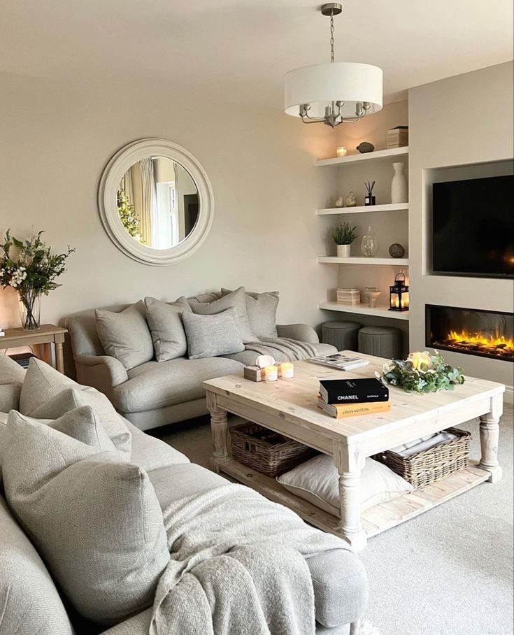 a living room filled with furniture and a flat screen tv mounted on a wall above a fire place