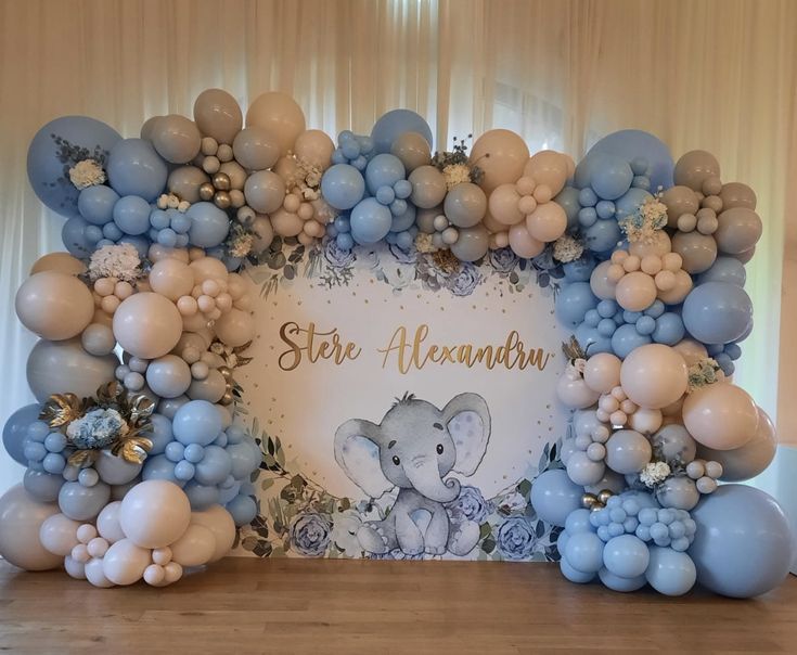 an elephant surrounded by balloons and flowers on a wooden table with a sign that says star aluna