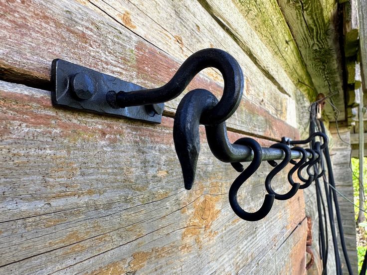 an iron hook on the side of a wooden wall