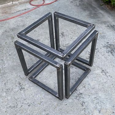 two metal cubes sitting on the ground next to each other